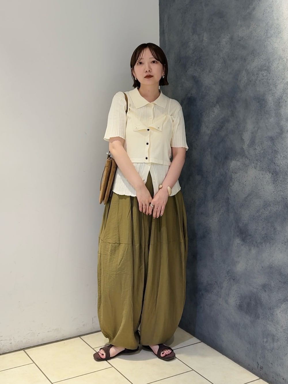 ホワイト系のニット/セーター、グリーン系のその他パンツ、ブラウン系のサンダルを着用したレディースの夏コーディネートの2枚目の写真