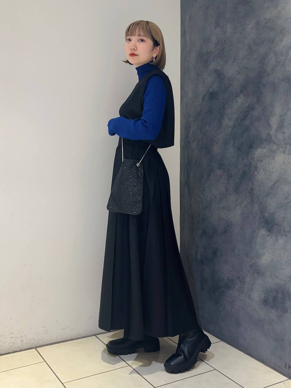 ブラック系のワンピース、ブルー系のニット/セーター、シルバー系のショルダーバッグを着用したレディースの冬コーディネートの3枚目の写真