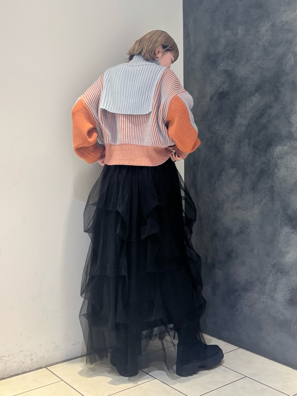 グレー系のニット/セーター、ブラック系のスカートを着用したレディースの冬コーディネートの4枚目の写真