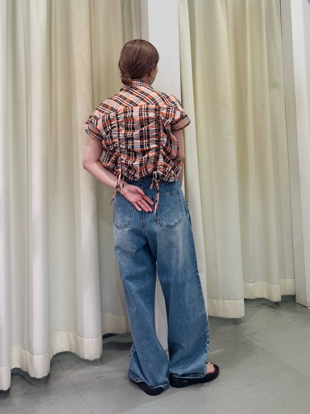 オレンジ系のシャツ/ブラウス、ブルー系のデニムパンツを着用したレディースの夏コーディネートの4枚目の写真