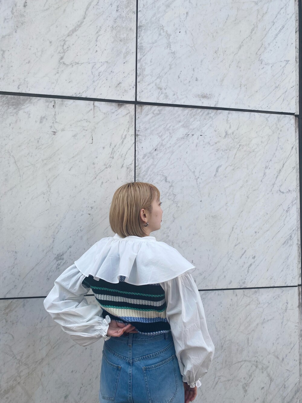 ブルー系のデニムパンツ、ホワイト系のシャツ/ブラウス、ブルー系のニット/セーターを着用したレディースの冬コーディネートの4枚目の写真