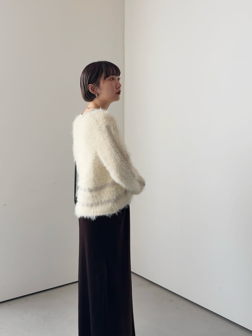 ホワイト系のニット/セーター、ブラウン系のスカートを着用したレディースの秋コーディネートの3枚目の写真