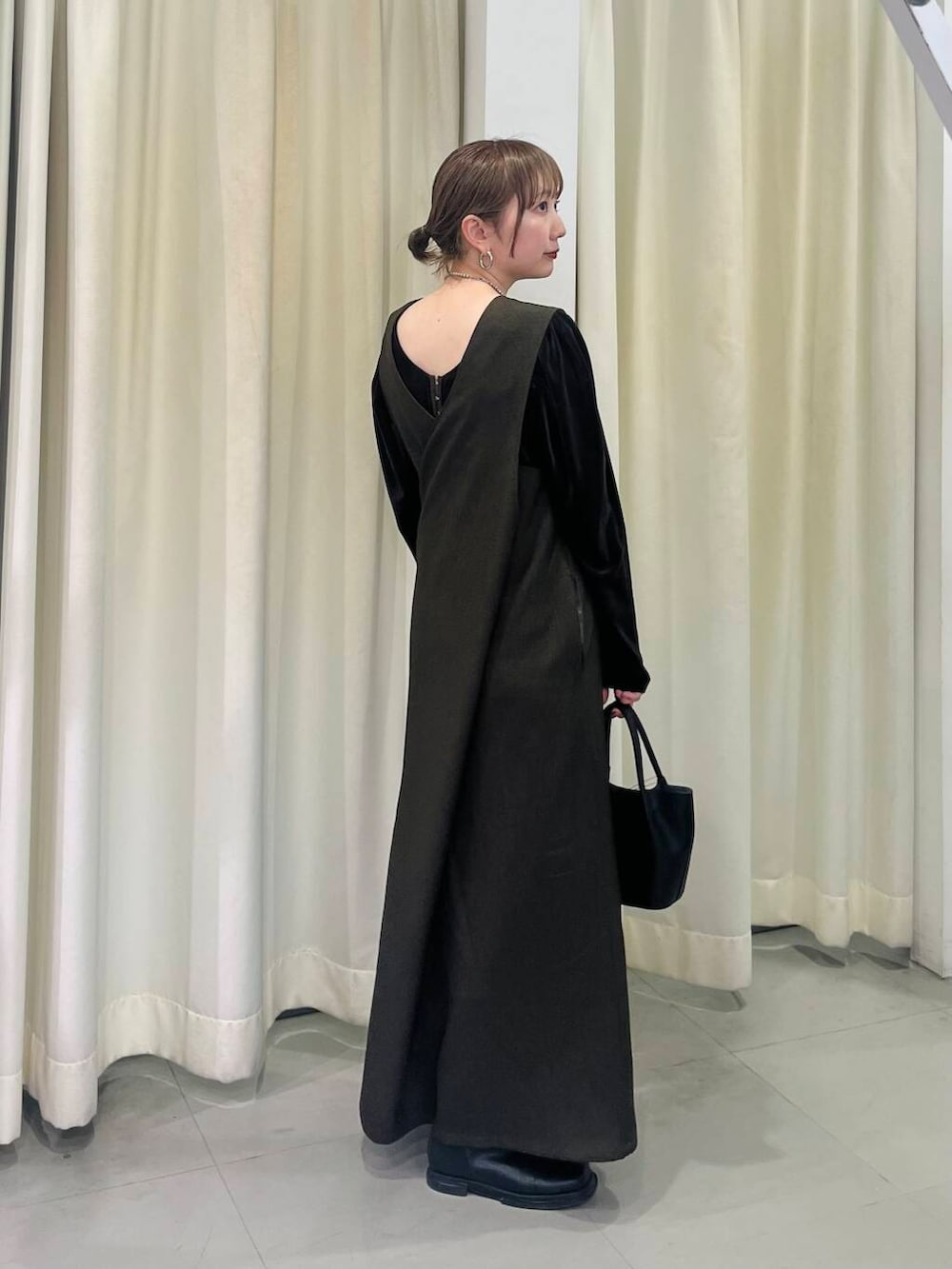 ブラック系のショルダーバッグ、ブラウン系のワンピース、ブラウン系のTシャツ/カットソーを着用したレディースの冬コーディネートの4枚目の写真