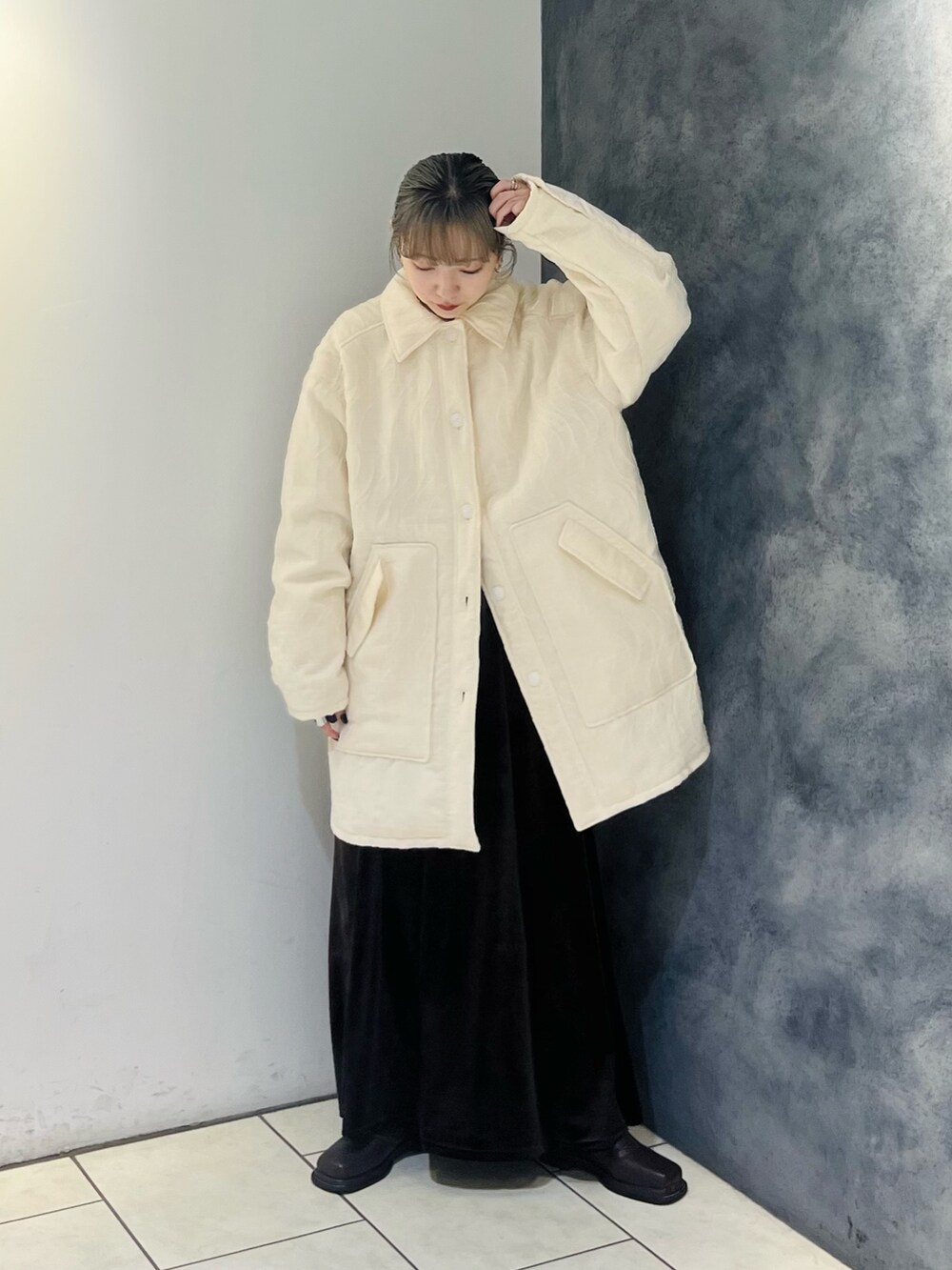 ホワイト系のダウンジャケット/コート、ブラウン系のスカートを着用したレディースの秋コーディネートの2枚目の写真