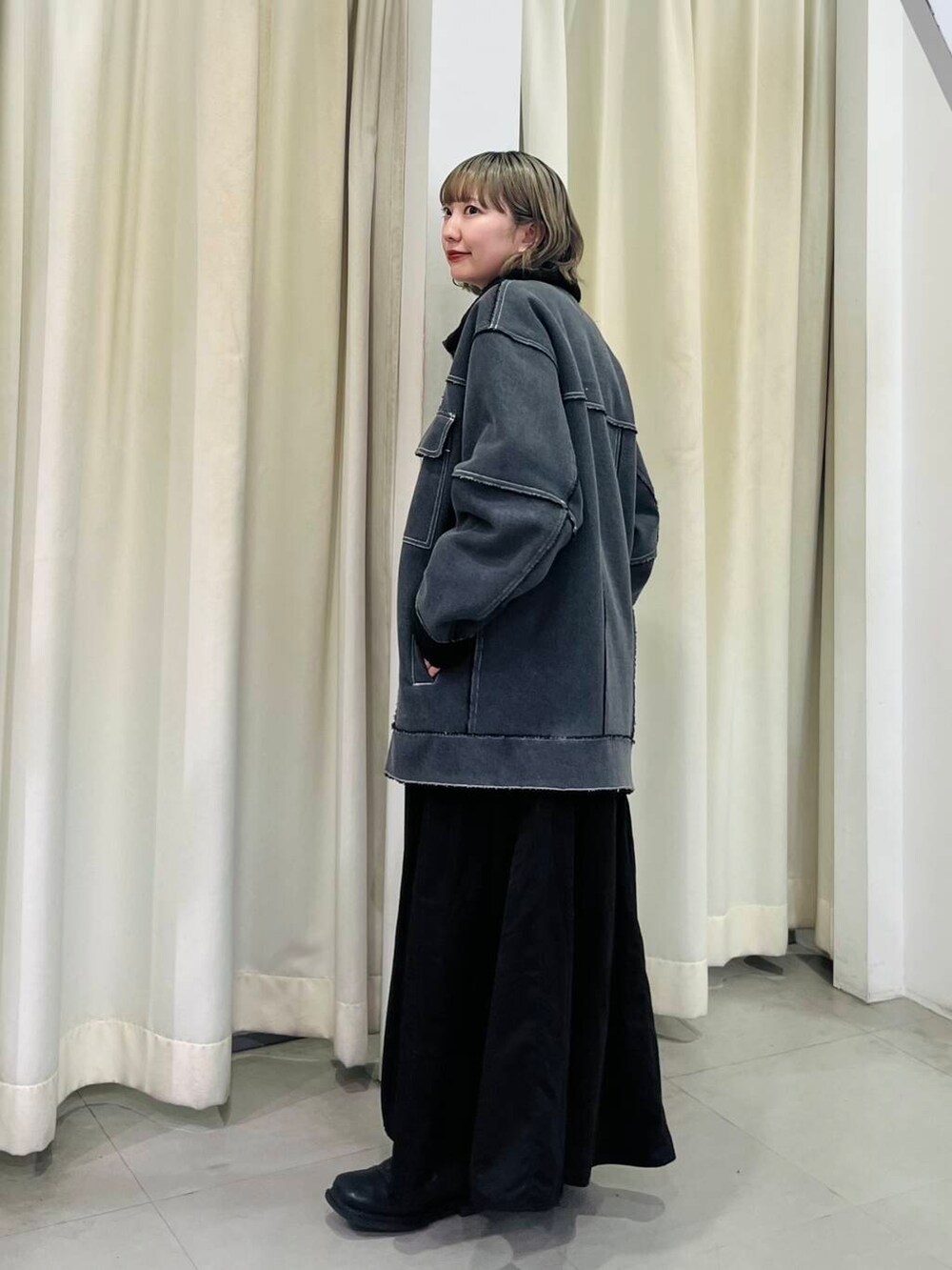 ブルー系のニット/セーター、ブラック系のその他アウター、ブラック系のワンピースを着用したレディースの秋コーディネートの4枚目の写真