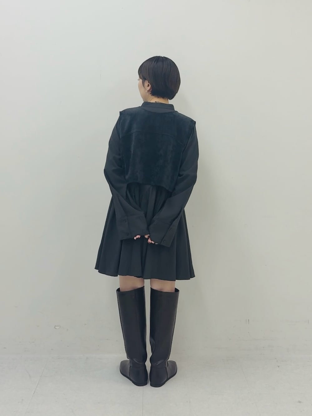 グレー系のワンピース、ブラウン系のブーツを着用したレディースの秋コーディネートの3枚目の写真