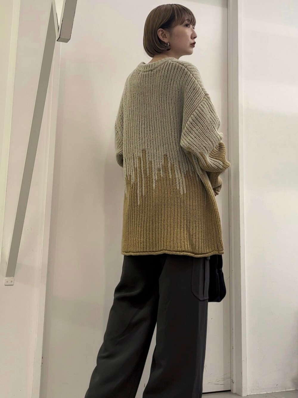 グレー系のニット/セーター、グレー系のその他パンツ、ブラック系のハンドバッグを着用したレディースの冬コーディネートの3枚目の写真