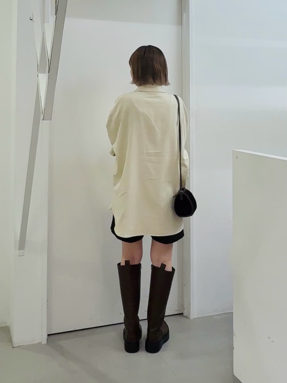 ホワイト系のシャツ/ブラウス、ブラウン系のブーツを着用したレディースの秋コーディネートの3枚目の写真