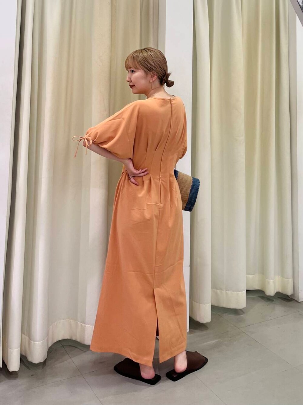 オレンジ系のワンピース、ブラウン系のサンダル、その他のトートバッグを着用したレディースの夏コーディネートの3枚目の写真