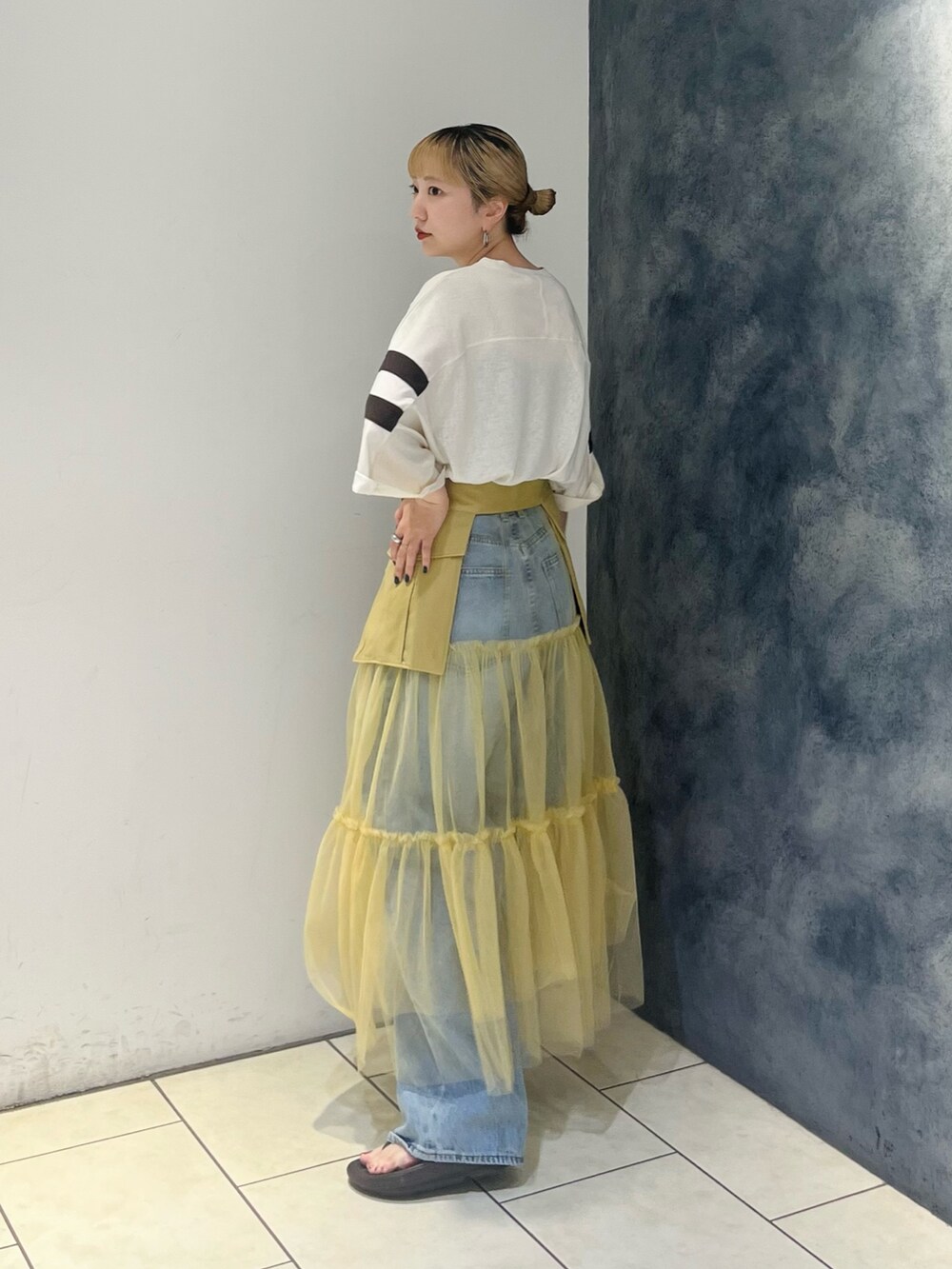 ホワイト系のTシャツ/カットソー、ベージュ系のスカート、ブルー系のデニムパンツを着用したレディースの夏コーディネートの3枚目の写真