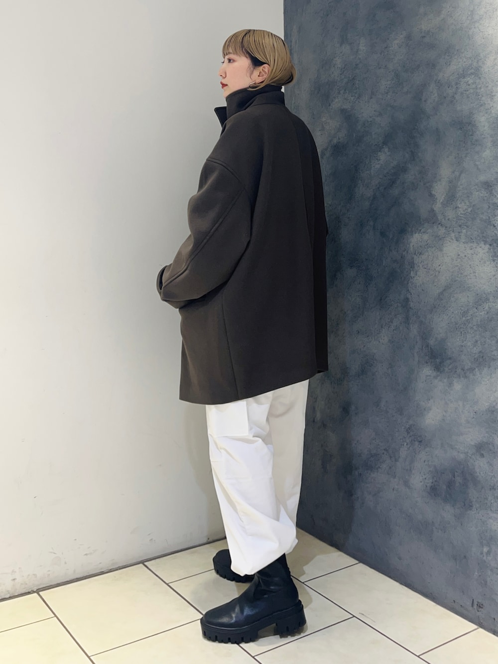 ブラウン系のその他アウター、ブルー系のニット/セーター、ホワイト系のカーゴパンツを着用したレディースの冬コーディネートの4枚目の写真