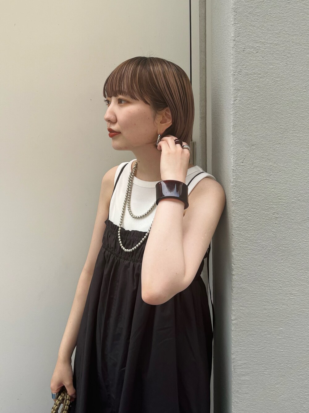 グレー系のサロペット/オーバーオール、ホワイト系のタンクトップ、ブラック系のサンダルを着用したレディースの夏コーディネートの5枚目の写真