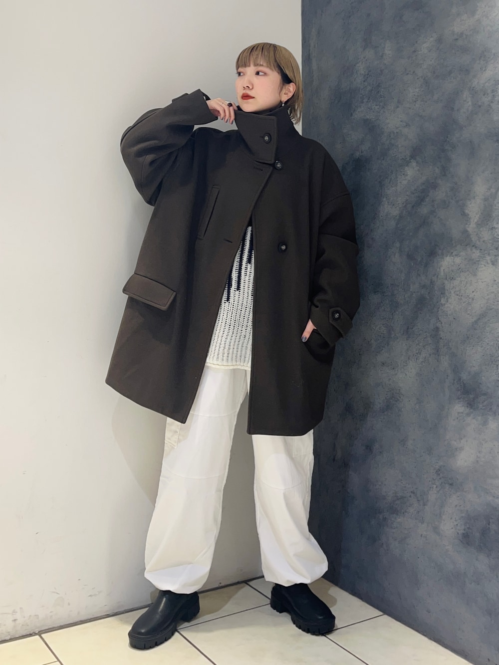 ブラウン系のその他アウター、ブルー系のニット/セーター、ホワイト系のカーゴパンツを着用したレディースの冬コーディネートの3枚目の写真