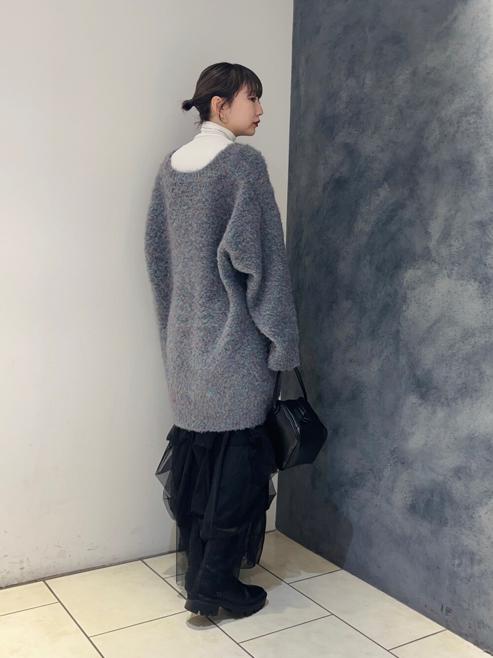 ブルー系のカーディガン/ボレロ、ブラック系のスカート、ホワイト系のTシャツ/カットソーを着用したレディースの秋コーディネートの3枚目の写真