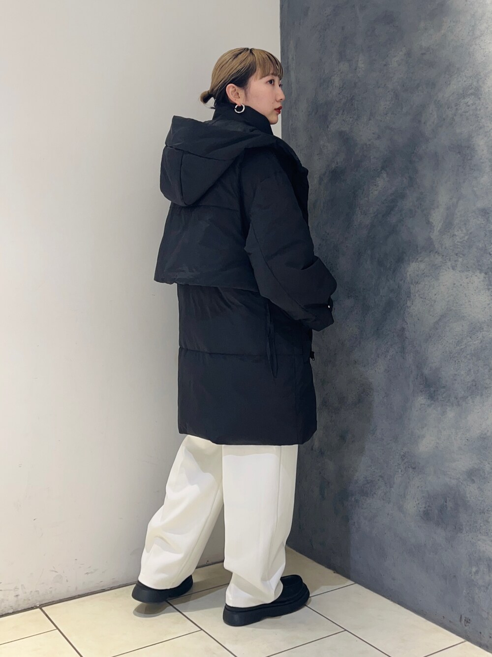 ブラック系のダウンジャケット/コート、ホワイト系のその他パンツ、ブルー系のニット/セーターを着用したレディースの冬コーディネートの4枚目の写真