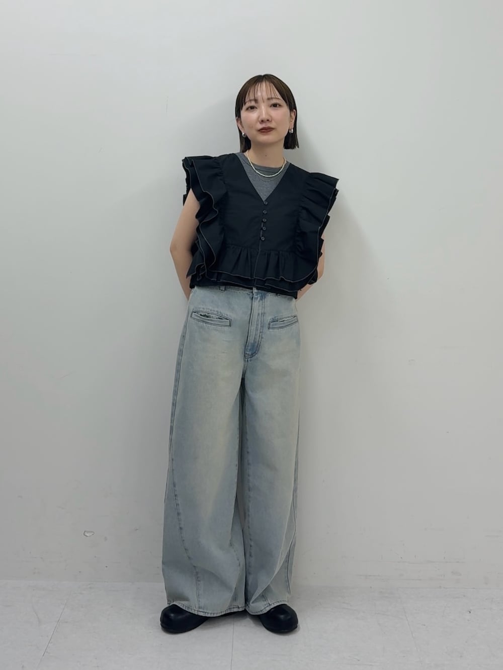 ブルー系のデニムパンツ、ブラック系のシャツ/ブラウス、グレー系のタンクトップを着用したレディースの春コーディネートの2枚目の写真