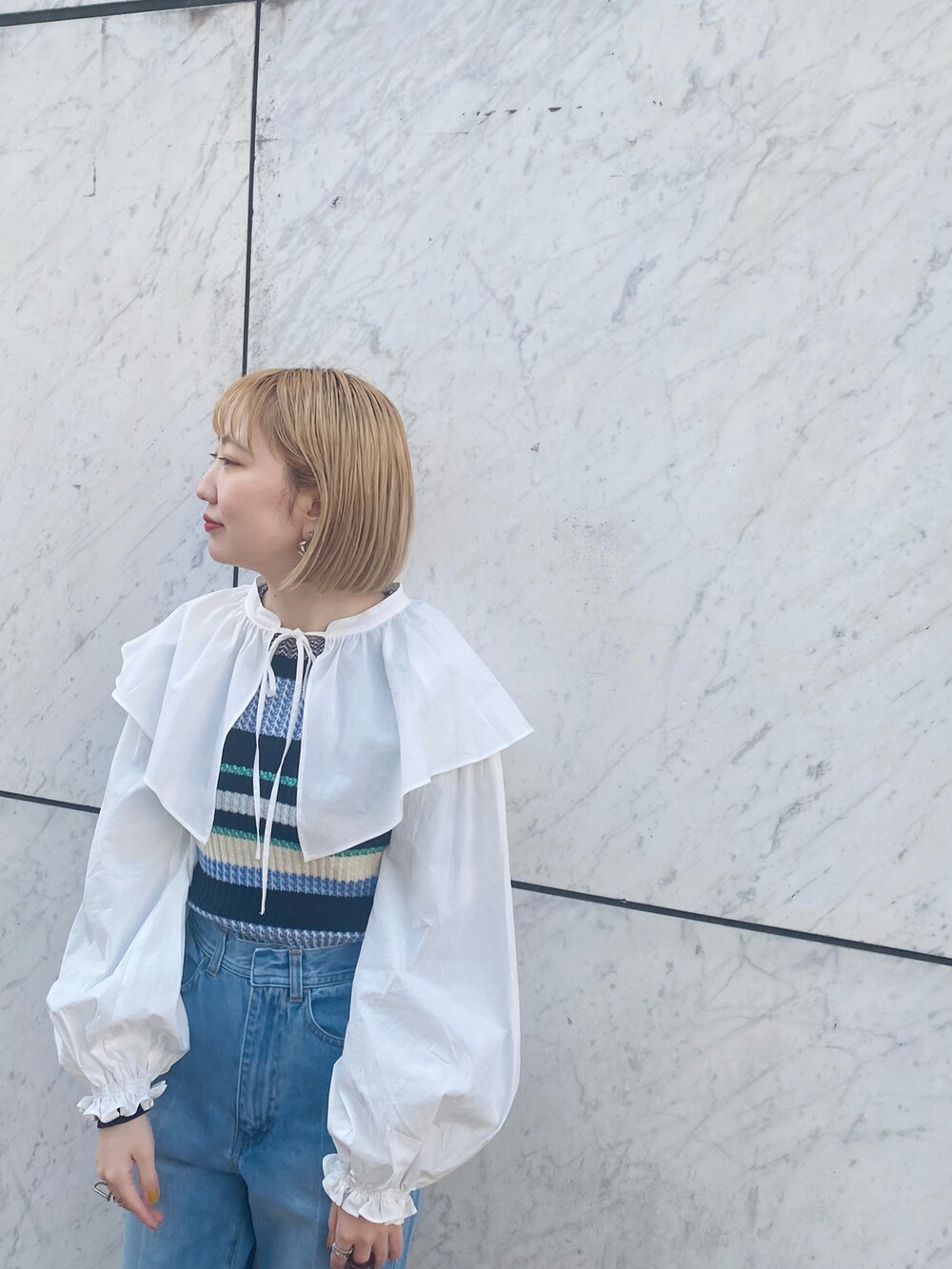 ブルー系のデニムパンツ、ホワイト系のシャツ/ブラウス、ブルー系のニット/セーターを着用したレディースの冬コーディネートの3枚目の写真