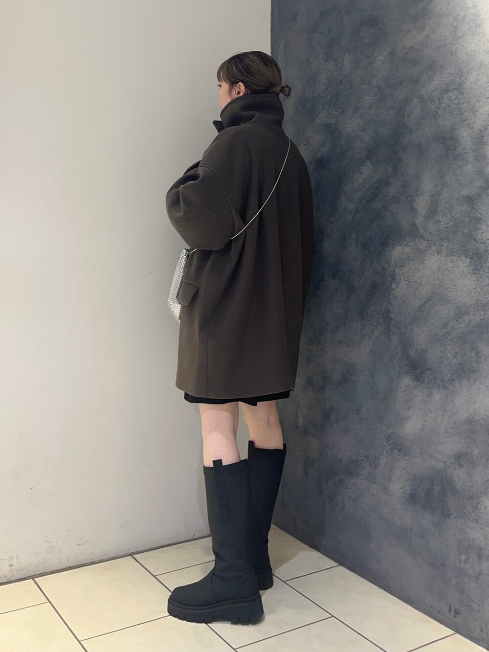 ブラウン系のその他アウター、ブラック系のブーツ、シルバー系のショルダーバッグを着用したレディースの秋コーディネートの5枚目の写真