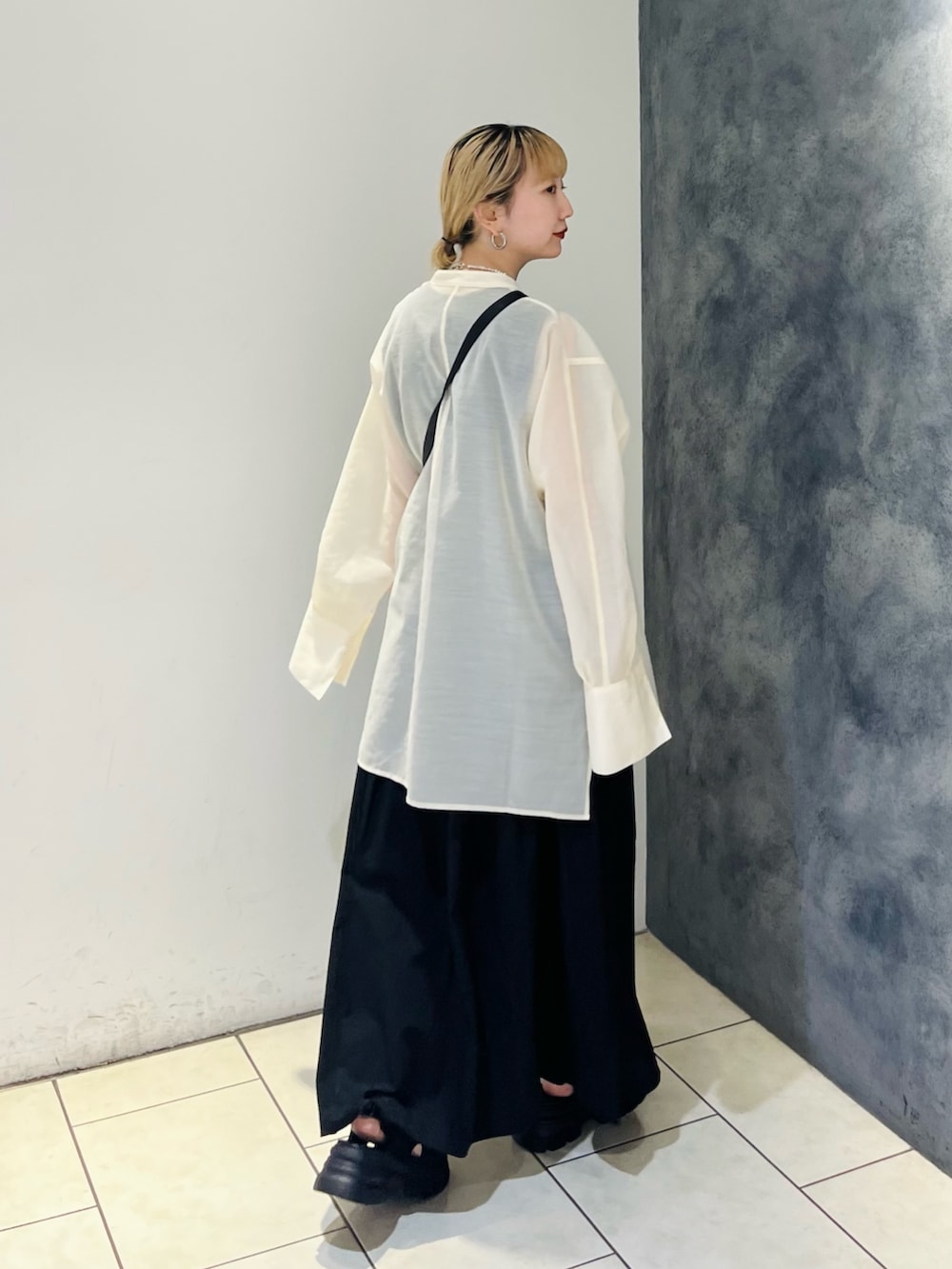 ブラック系のワンピース、ホワイト系のシャツ/ブラウス、ブラック系のサンダルを着用したレディースの夏コーディネートの3枚目の写真