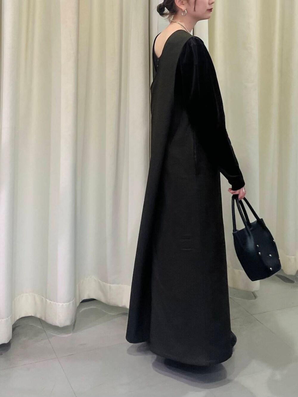 ブラック系のショルダーバッグ、ブラウン系のワンピース、ブラウン系のTシャツ/カットソーを着用したレディースの冬コーディネートの3枚目の写真