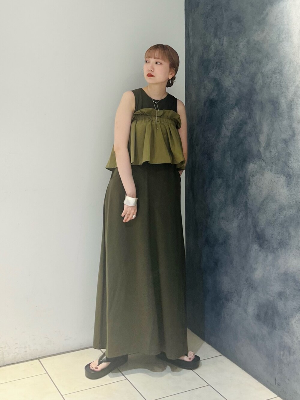 グリーン系のワンピース、ブラック系のサンダルを着用したレディースの夏コーディネートの2枚目の写真