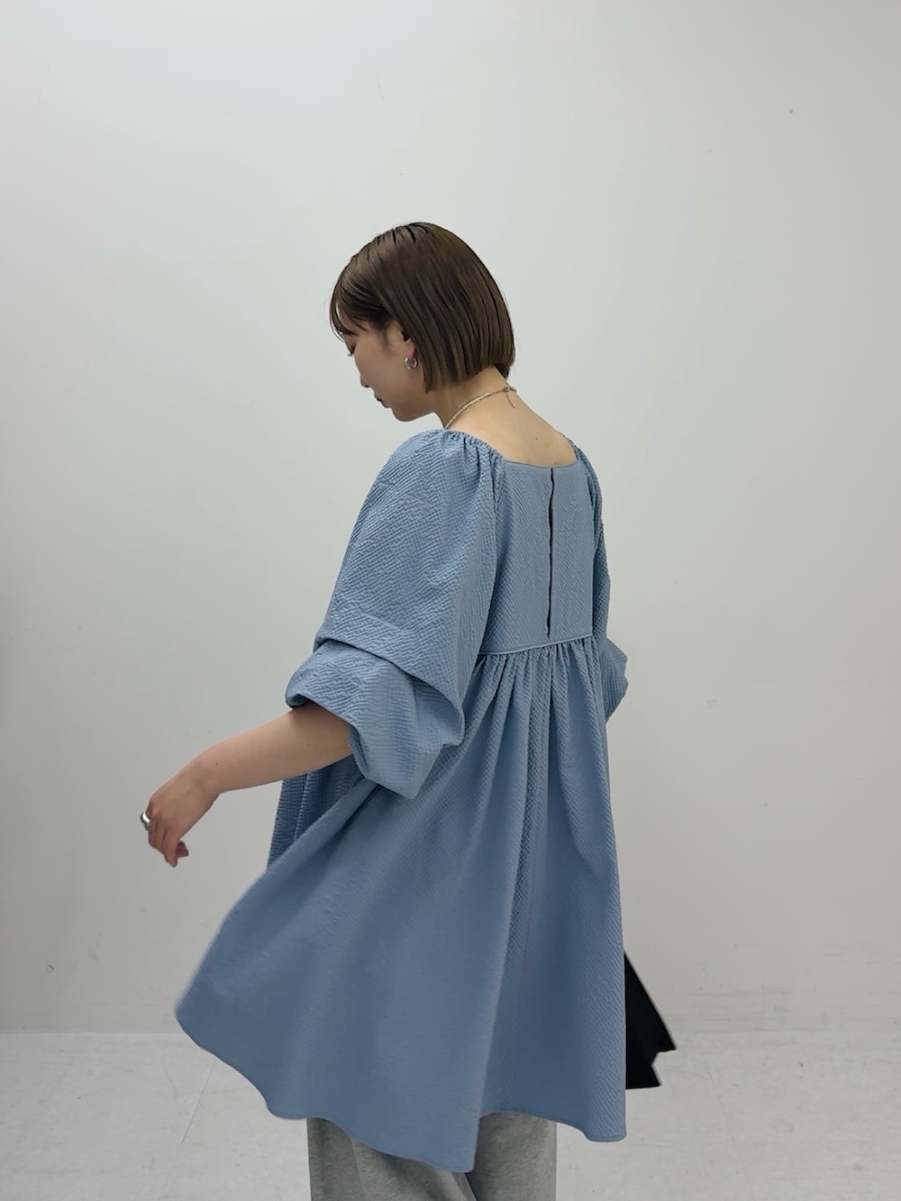 ブルー系のワンピース、グレー系のその他パンツ、ブラック系のハンドバッグを着用したレディースの春コーディネートの3枚目の写真