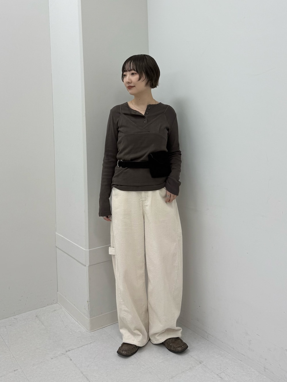 ブラウン系のTシャツ/カットソー、ホワイト系のその他パンツ、ブラック系のボディバッグ/ウエストポーチを着用したレディースの秋コーディネートの2枚目の写真