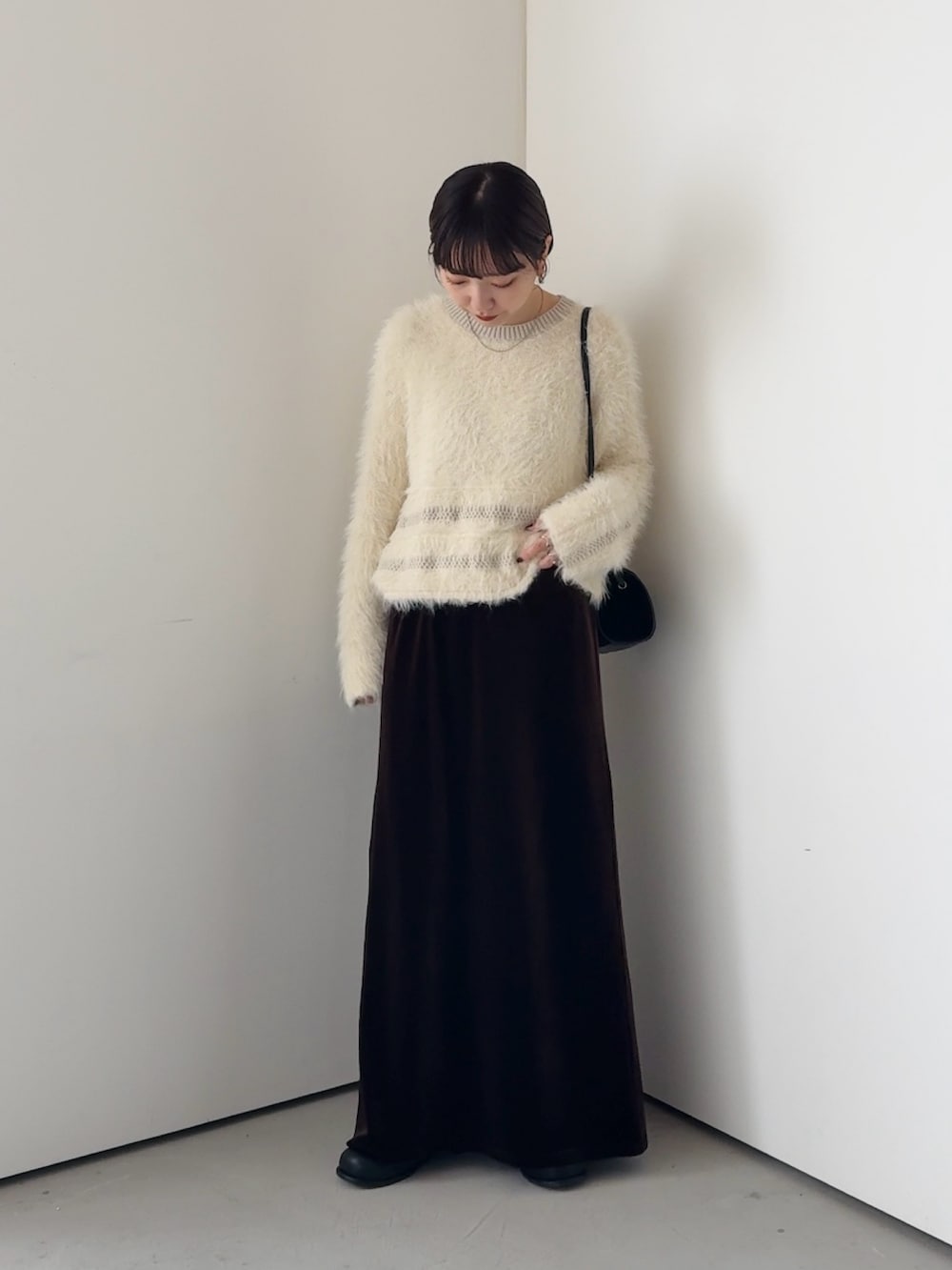 ホワイト系のニット/セーター、ブラウン系のスカートを着用したレディースの秋コーディネートの2枚目の写真