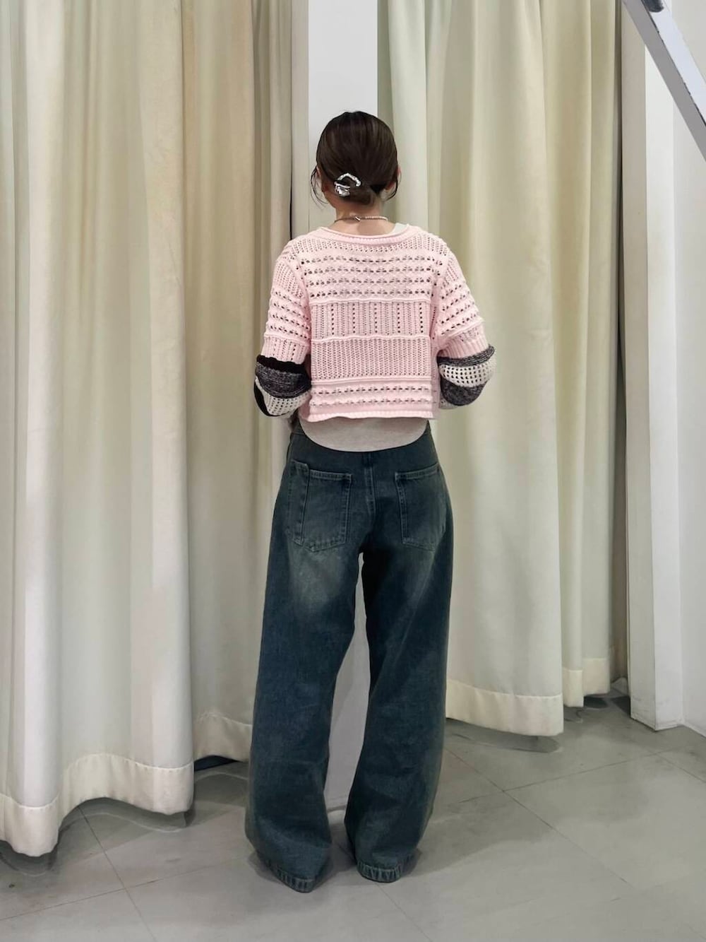 ブルー系のデニムパンツ、ベージュ系のタンクトップ、ピンク系のカーディガン/ボレロを着用したレディースの春コーディネートの3枚目の写真