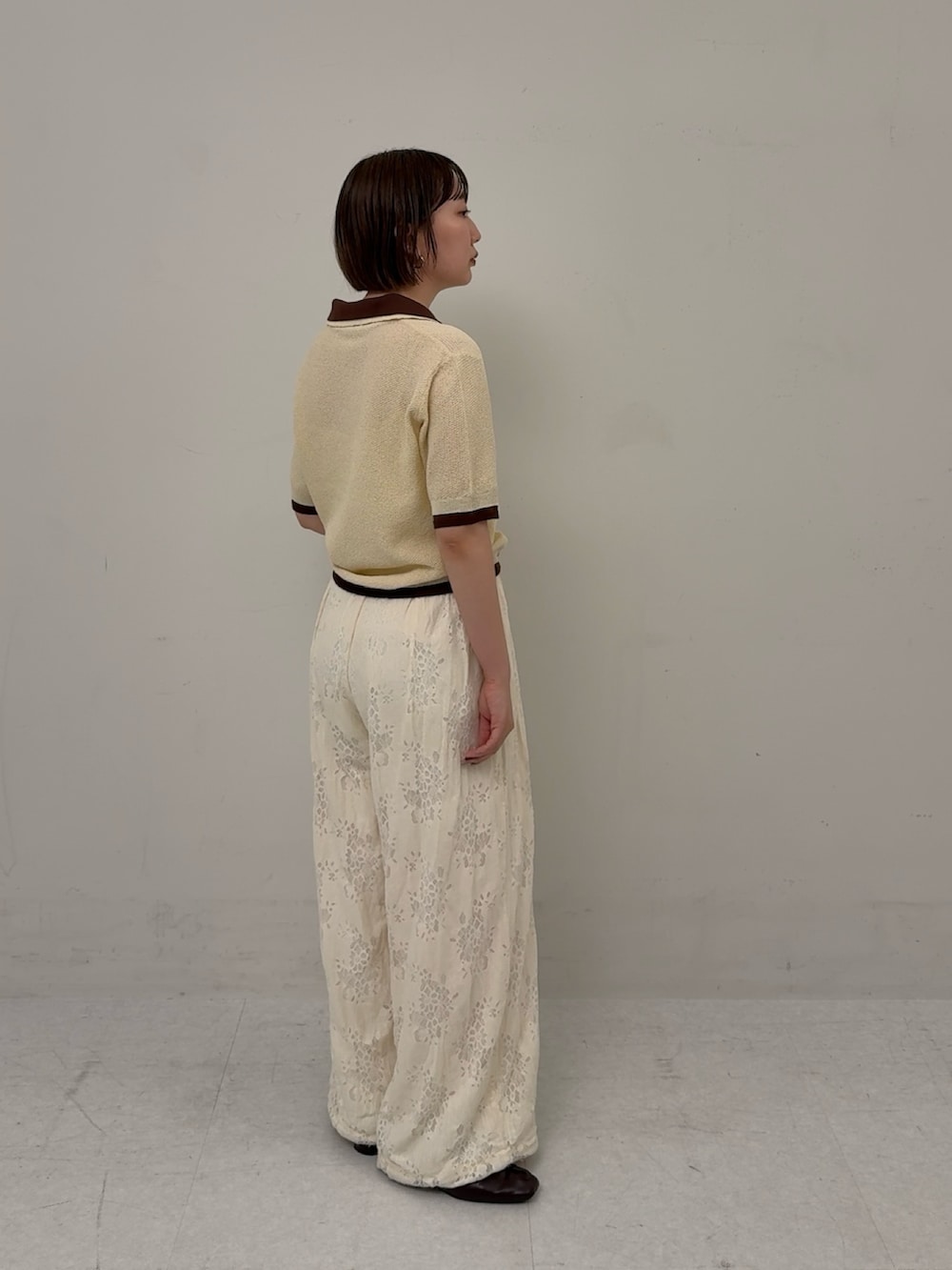 イエロー系のニット/セーター、ホワイト系のその他パンツを着用したレディースの春コーディネートの2枚目の写真