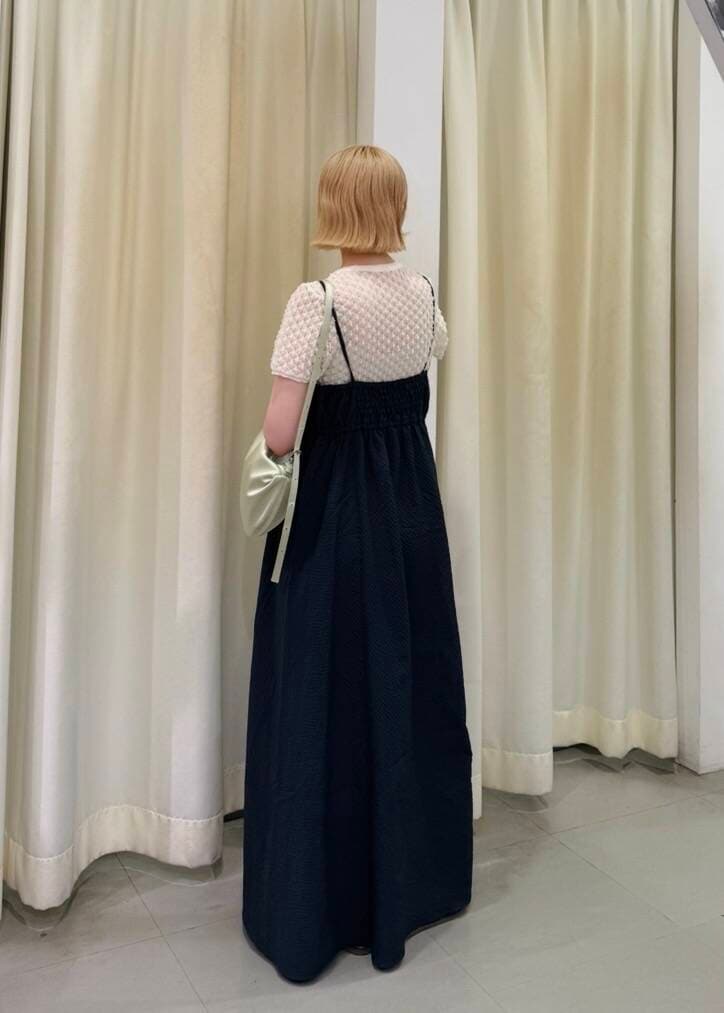 ブルー系のワンピース、グリーン系のショルダーバッグ、ホワイト系のニット/セーターを着用したレディースの夏コーディネートの2枚目の写真