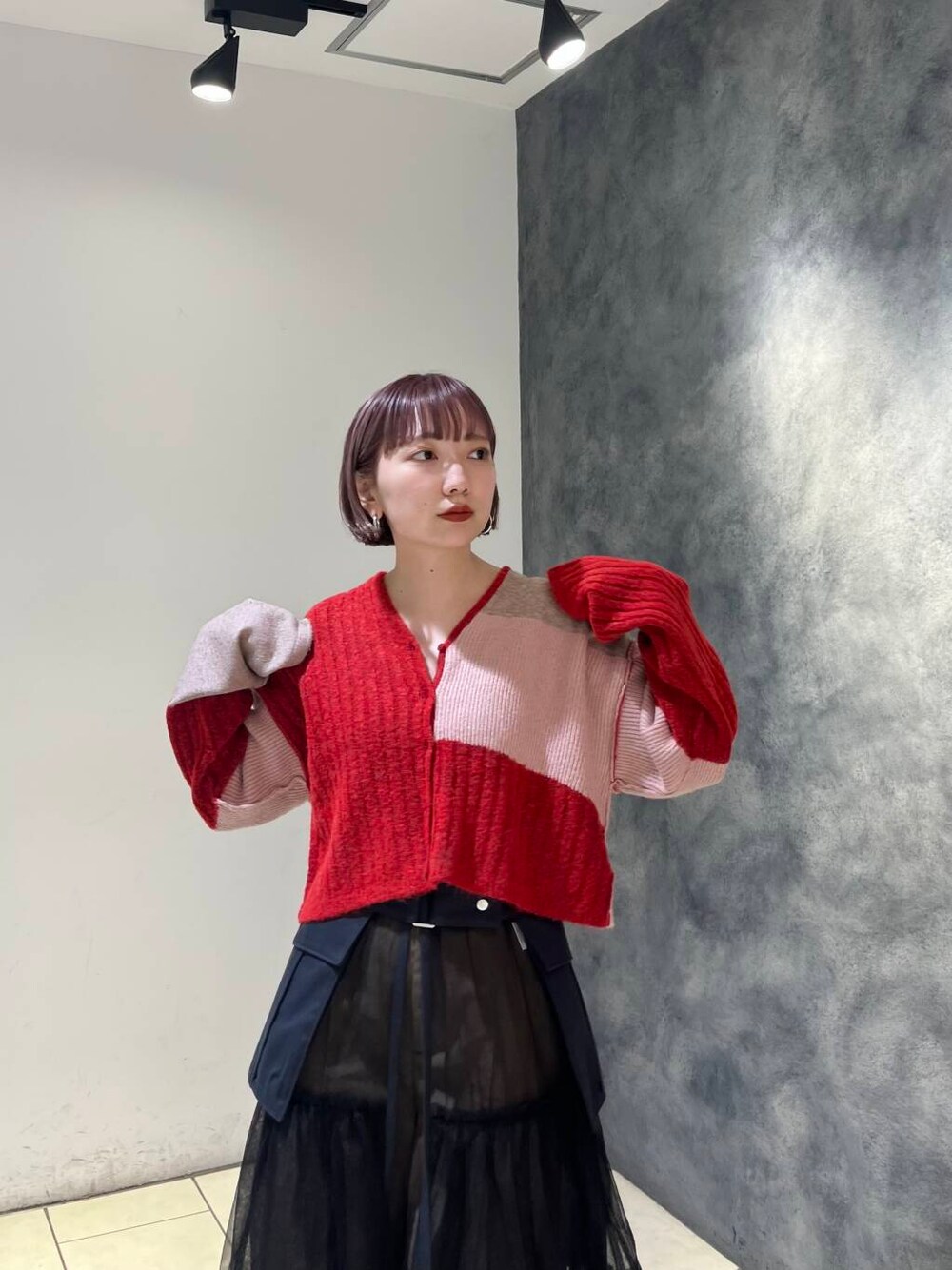 グレー系のスカート、ブラウン系のその他パンツ、レッド系のニット/セーターを着用したレディースの夏コーディネートの5枚目の写真