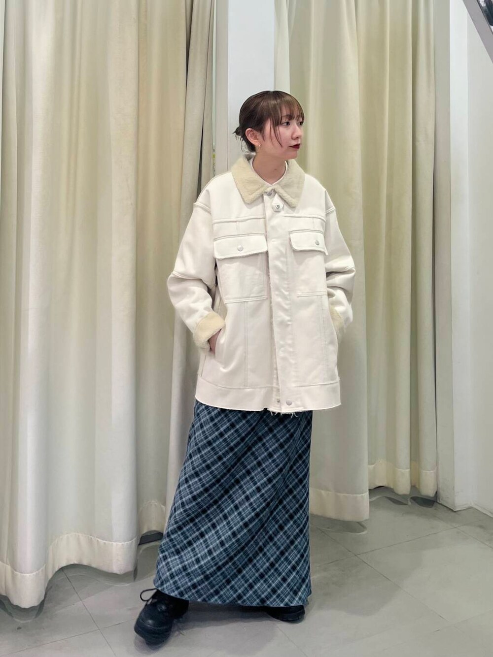 ホワイト系のその他アウター、グレー系のスカートを着用したレディースの冬コーディネートの2枚目の写真