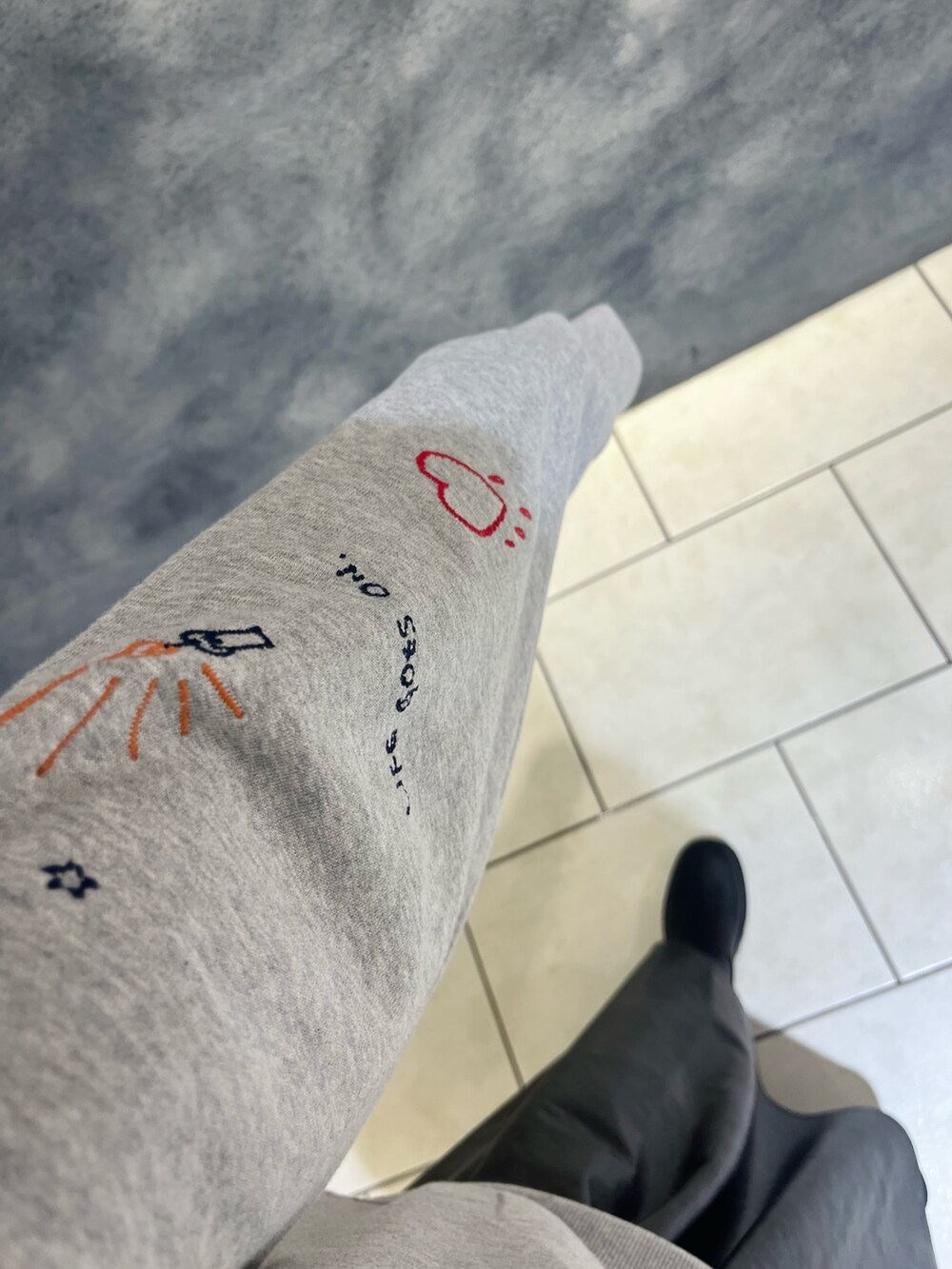 グレー系のスウェット、ブラック系のスカートを着用したレディースの秋コーディネートの4枚目の写真