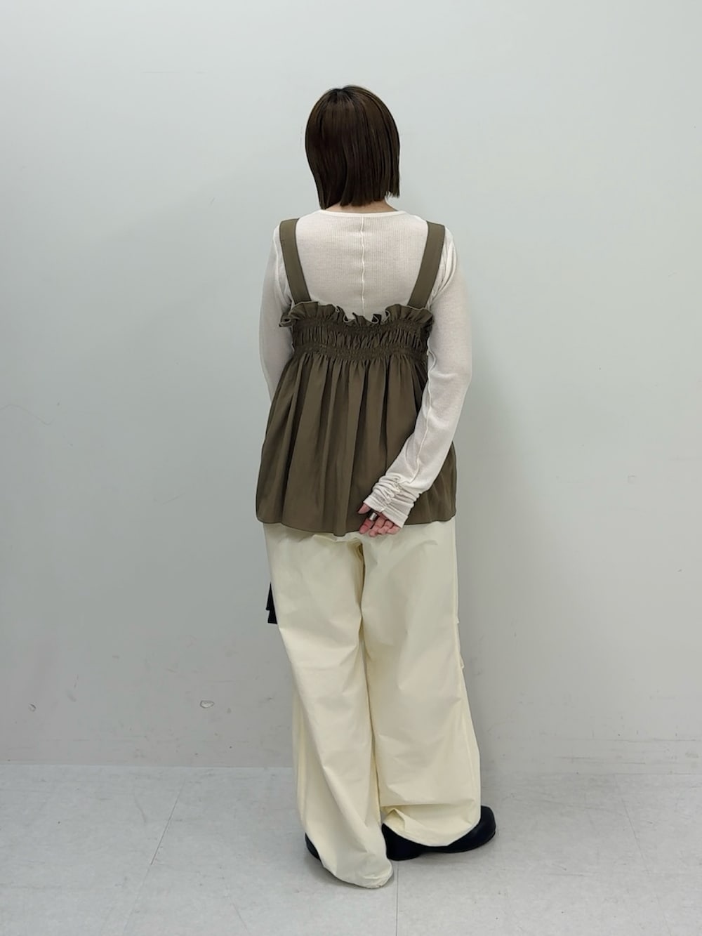 グリーン系のその他トップス、ブラック系のハンドバッグ、ホワイト系のその他パンツを着用したレディースの春コーディネートの2枚目の写真