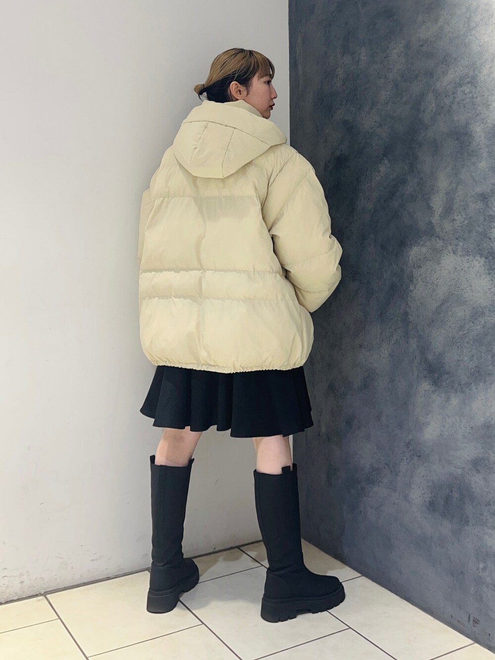 ベージュ系のダウンジャケット/コート、ブラック系のワンピース、ブラック系のブーツを着用したレディースの冬コーディネートの5枚目の写真