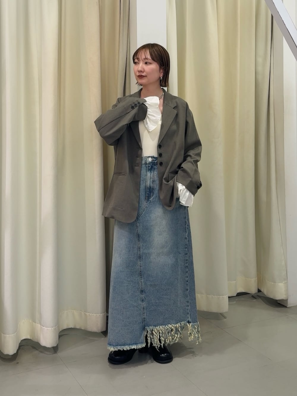 グレー系のその他アウター、ブルー系のスカートを着用したレディースの春コーディネートの3枚目の写真