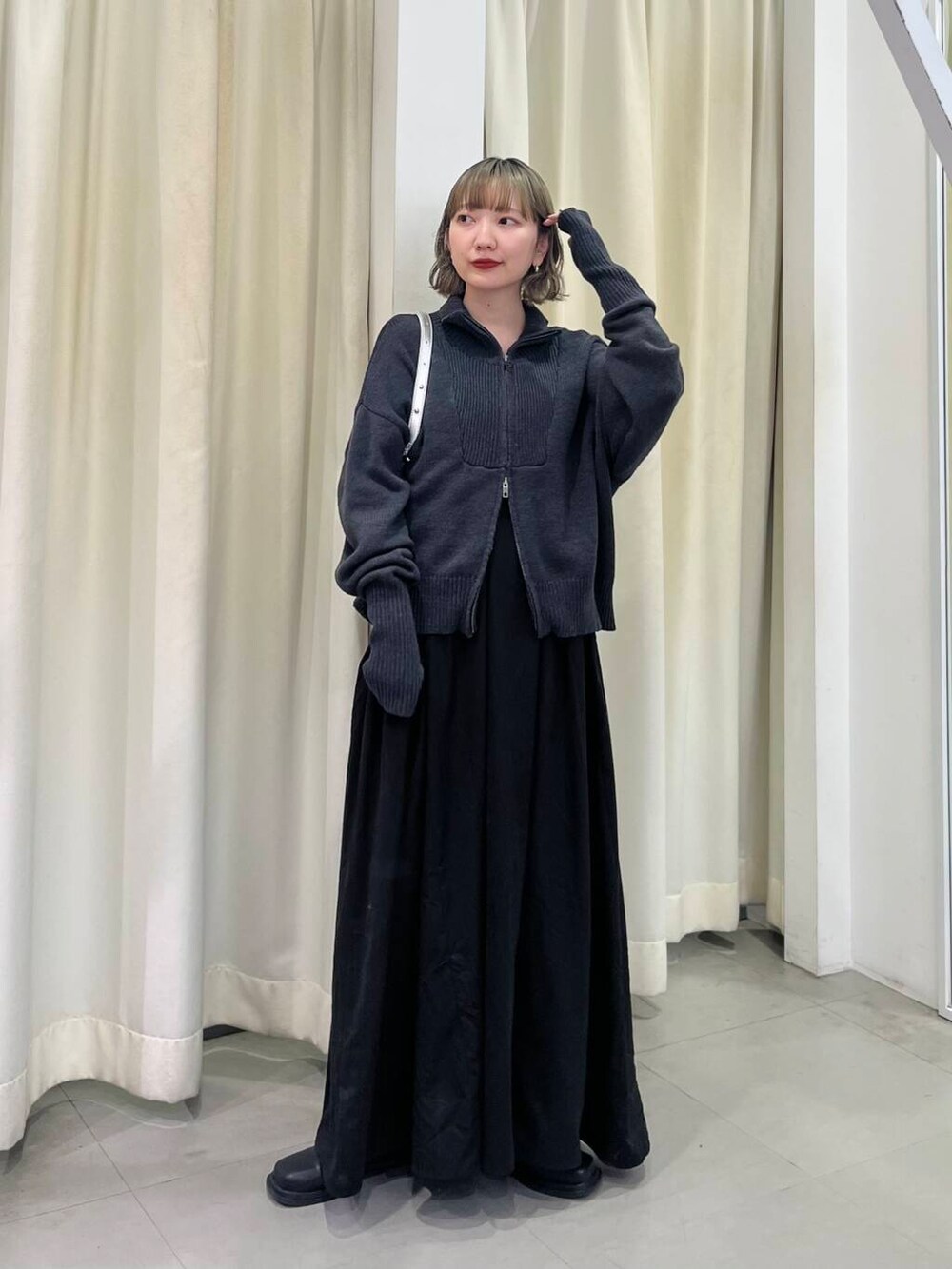 ブラック系のワンピース、シルバー系のショルダーバッグを着用したレディースの秋コーディネートの3枚目の写真