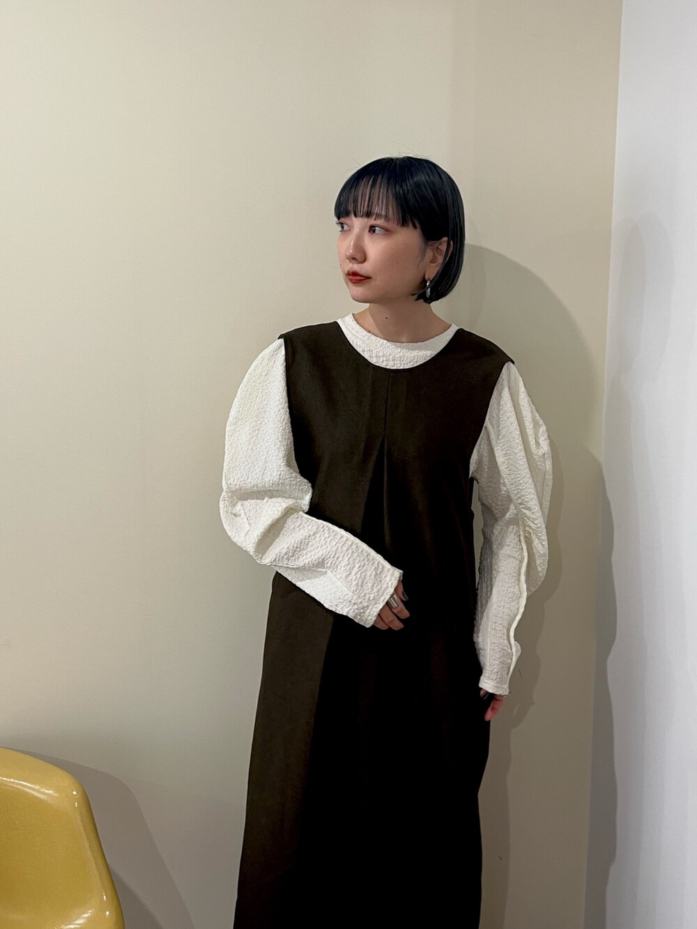 ブラウン系のワンピース、ホワイト系のTシャツ/カットソー、ブラウン系のブーツを着用したレディースの秋コーディネートの4枚目の写真