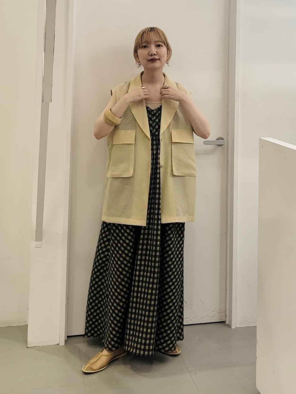 ベージュ系のベスト、グリーン系のワンピース、ベージュ系のその他シューズを着用したレディースの春コーディネートの2枚目の写真