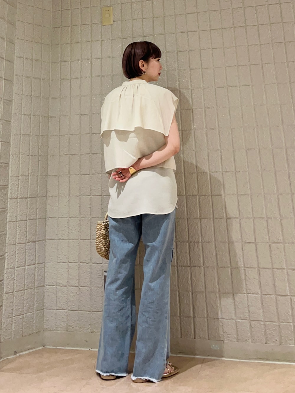 ホワイト系のシャツ/ブラウス、ブルー系のデニムパンツ、ゴールド系のサンダルを着用したレディースの夏コーディネートの3枚目の写真