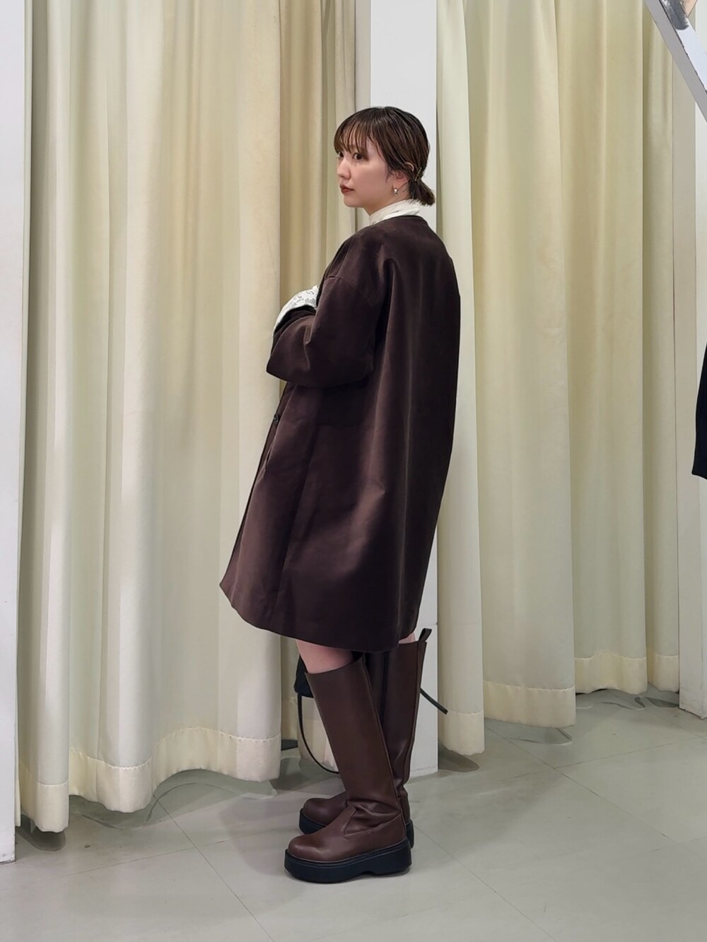 ブラウン系のその他アウター、ブラウン系のブーツ、ホワイト系のTシャツ/カットソーを着用したレディースの秋コーディネートの2枚目の写真