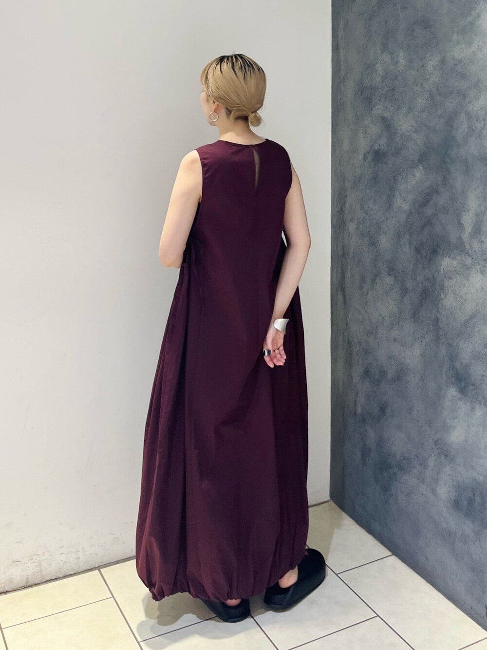 レッド系のワンピース、ブラック系のサンダル、ホワイト系のネックレスを着用したレディースの夏コーディネートの3枚目の写真