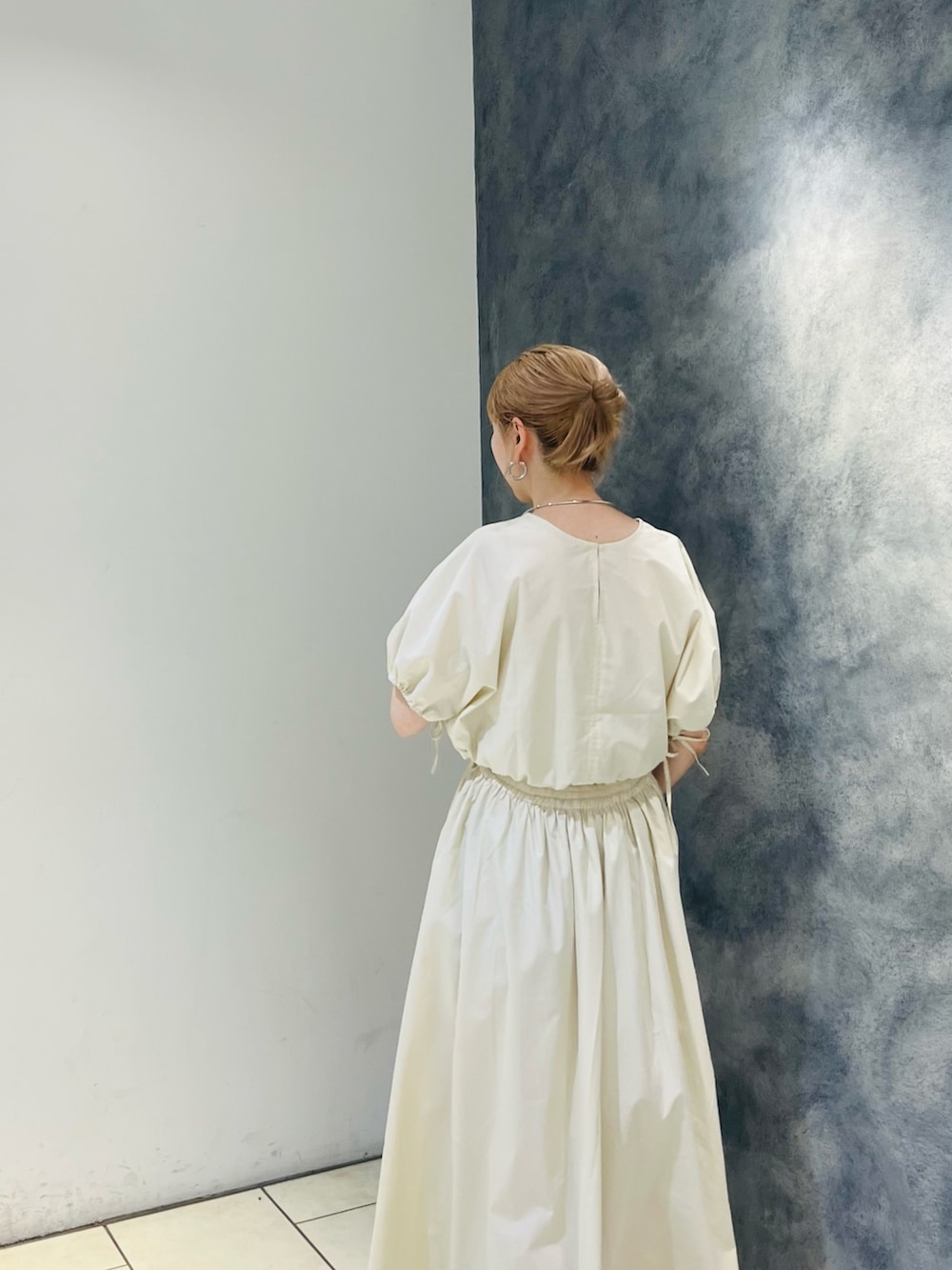 オレンジ系のワンピース、ホワイト系のサンダルを着用したレディースの夏コーディネートの4枚目の写真