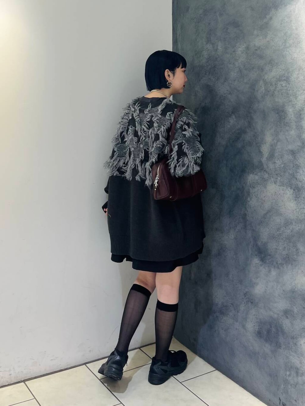 レッド系のボストンバッグ、ブラック系のワンピース、グレー系のTシャツ/カットソーを着用したレディースの秋コーディネートの4枚目の写真