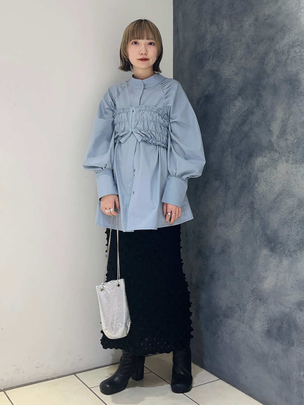 ブルー系のシャツ/ブラウス、ブラック系のスカート、ブラック系のブーツを着用したレディースの冬コーディネートの2枚目の写真