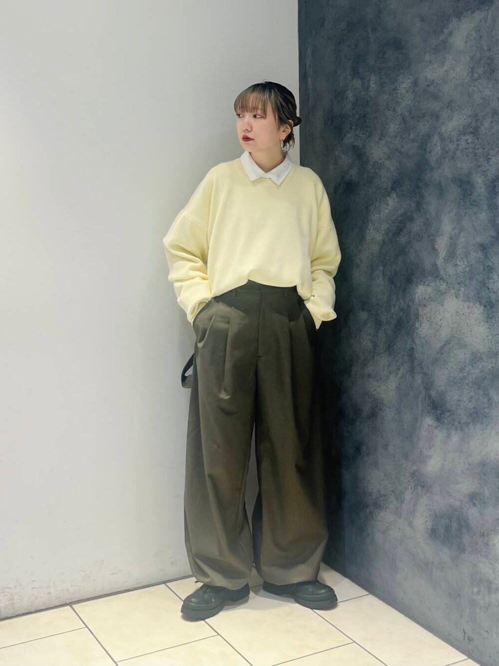 グリーン系のその他パンツ、ホワイト系のシャツ/ブラウス、イエロー系のニット/セーターを着用したレディースの冬コーディネートの2枚目の写真