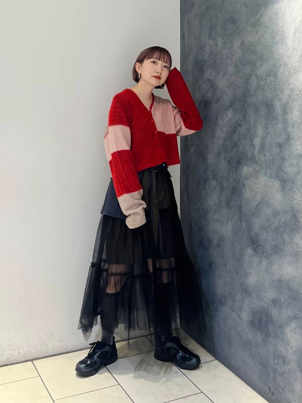 グレー系のスカート、ブラウン系のその他パンツ、レッド系のニット/セーターを着用したレディースの夏コーディネートの2枚目の写真