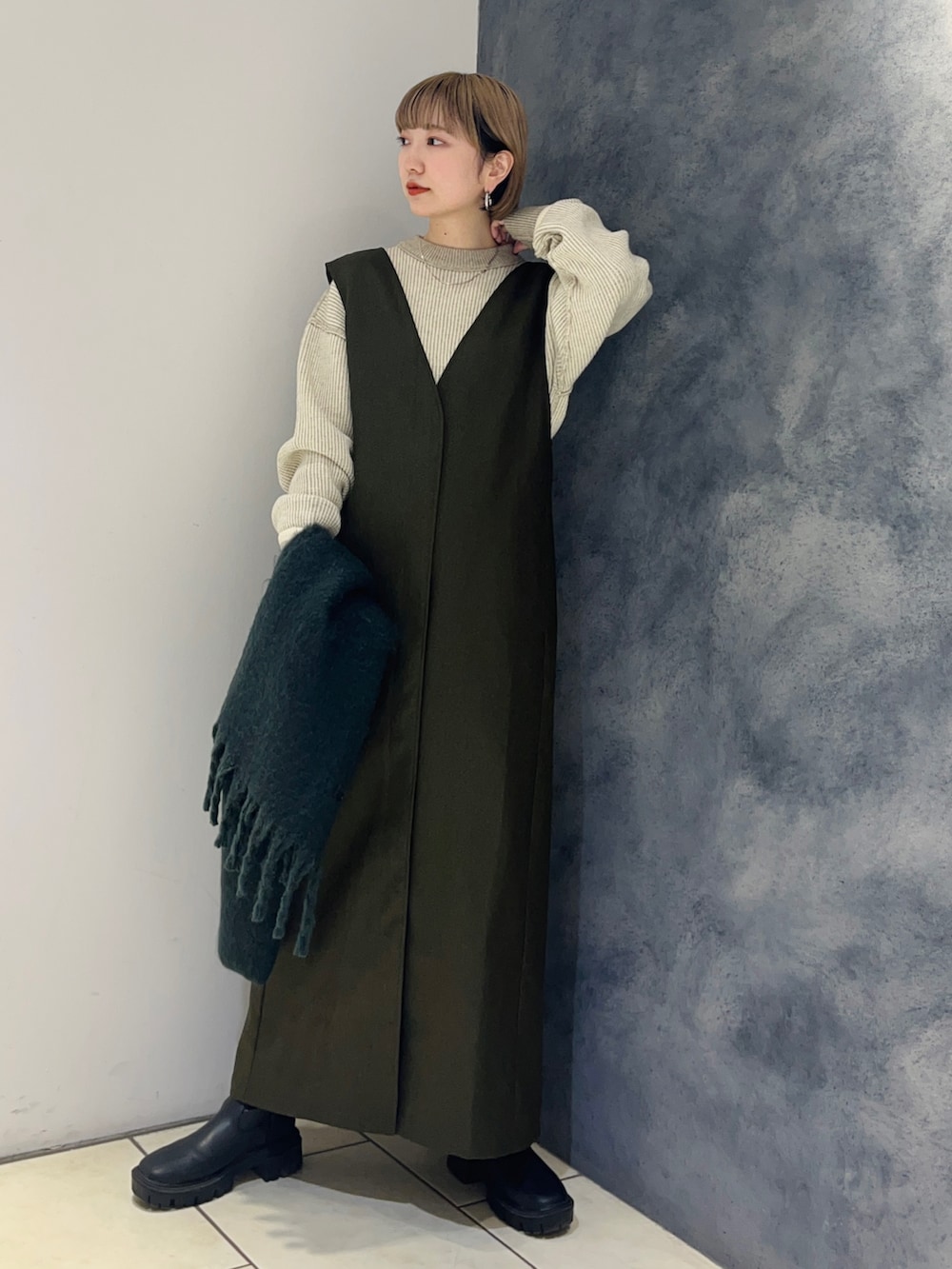 ホワイト系のニット/セーター、グリーン系のワンピース、グリーン系のマフラーを着用したレディースの冬コーディネートの3枚目の写真