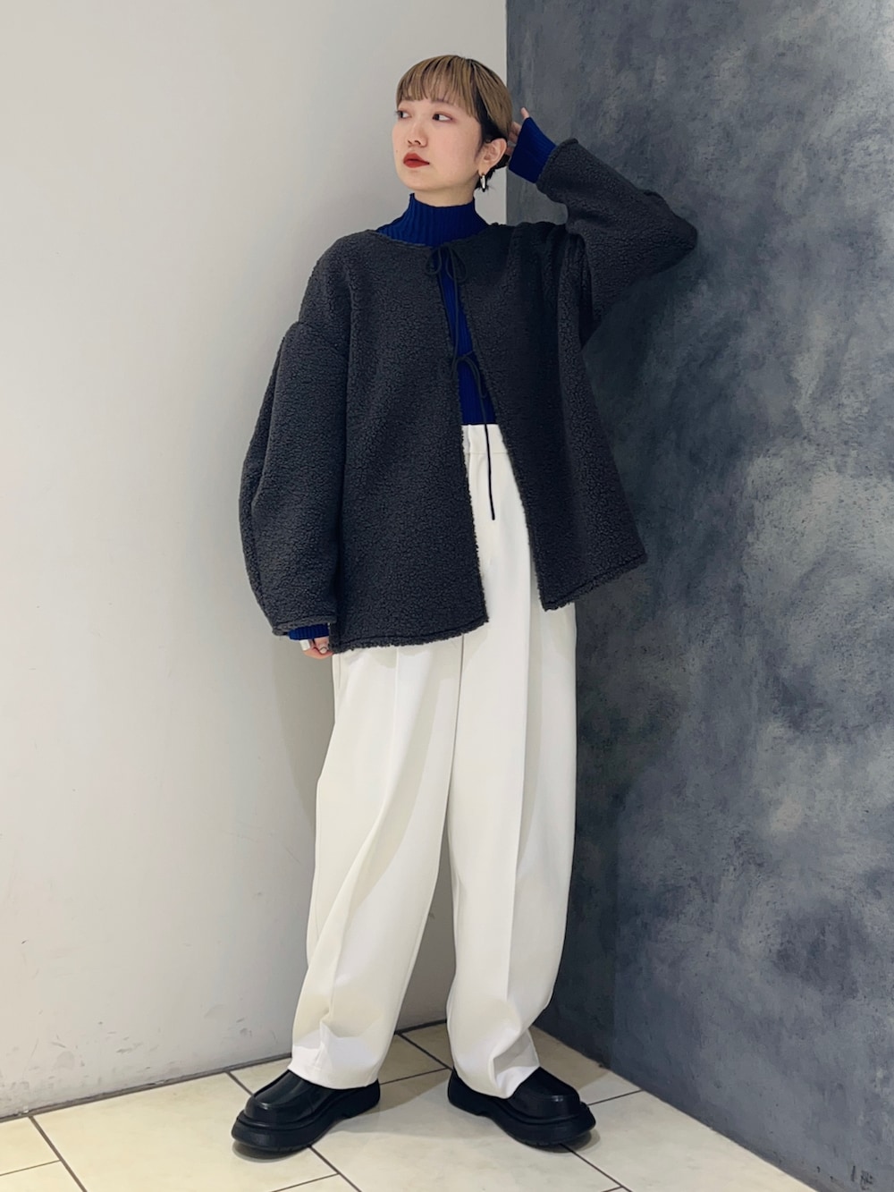 ブルー系のニット/セーター、グレー系のその他トップス、ホワイト系のその他パンツを着用したレディースの冬コーディネートの2枚目の写真